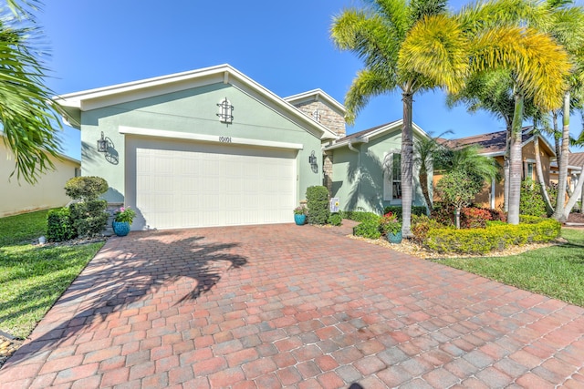 single story home with decorative driveway, a garage, and stucco siding