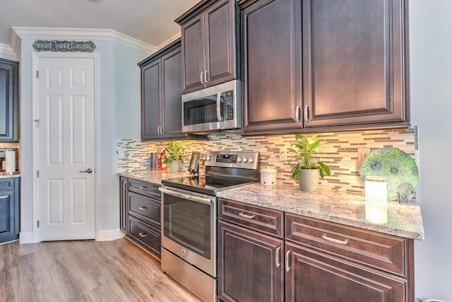 kitchen featuring crown molding, light stone countertops, backsplash, and stainless steel appliances