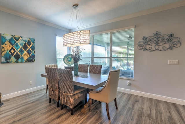 dining area with baseboards, a textured ceiling, wood finished floors, and crown molding