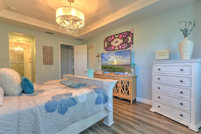 bedroom with a tray ceiling, visible vents, a chandelier, and crown molding