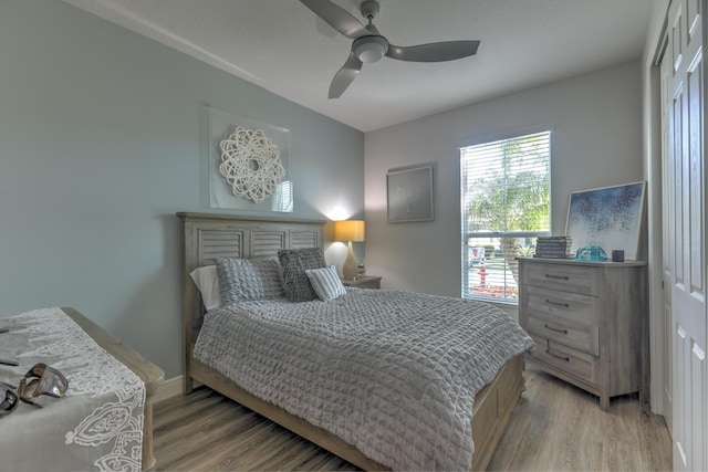 bedroom featuring a ceiling fan, light wood-style floors, and baseboards