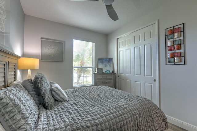 bedroom featuring wood finished floors, baseboards, a closet, and ceiling fan