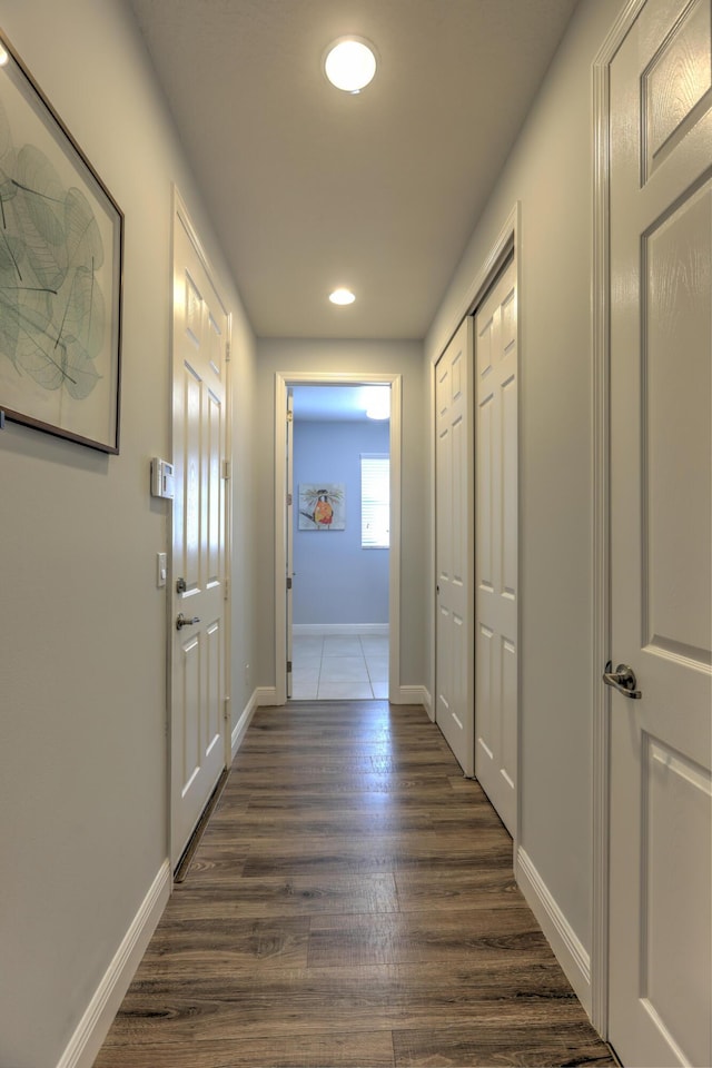 hall with dark wood finished floors, recessed lighting, and baseboards