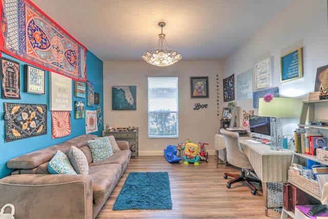 office space with a chandelier, baseboards, and wood finished floors