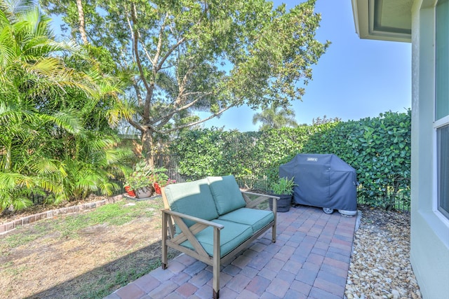 view of patio with area for grilling, outdoor lounge area, and fence