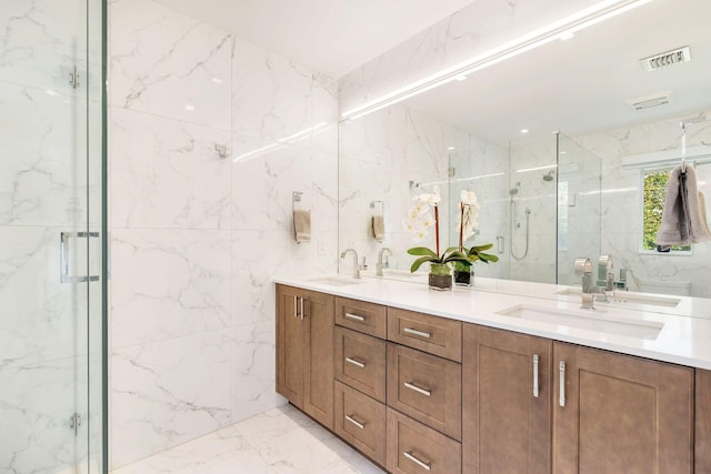 bathroom featuring a marble finish shower, visible vents, marble finish floor, and a sink