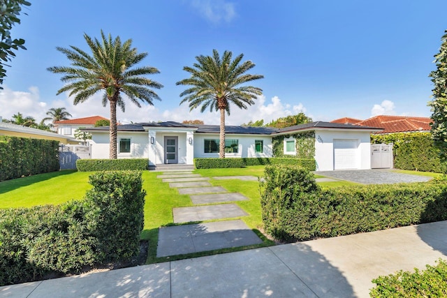 view of front of house featuring a garage, stucco siding, a front yard, and fence