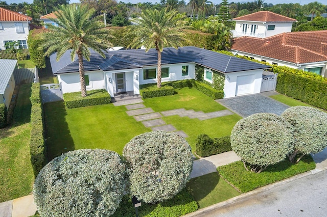 view of front facade with stucco siding, a front lawn, decorative driveway, fence, and an attached garage