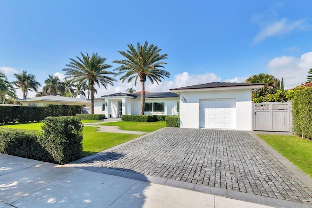 ranch-style house with a gate, fence, stucco siding, a front lawn, and decorative driveway