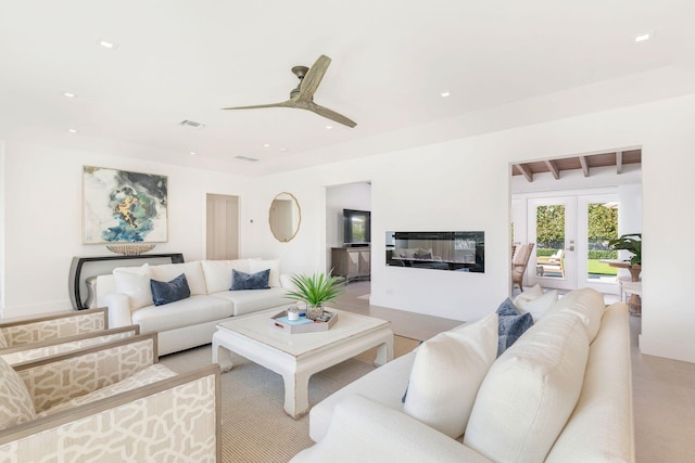 living area featuring beam ceiling, visible vents, recessed lighting, and a glass covered fireplace