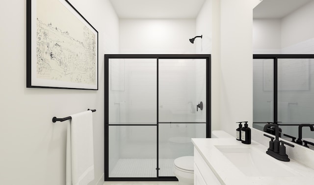 bathroom with a shower stall, toilet, and vanity