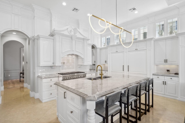 4216 Intracoastal Dr, Highland Beach, FL 33487 - kitchen with a sink, arched walkways, white cabinetry, range, and a towering ceiling