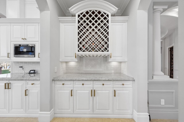 4216 Intracoastal Dr, Highland Beach, FL 33487 - kitchen featuring ornamental molding, light stone countertops, decorative backsplash, and white cabinets