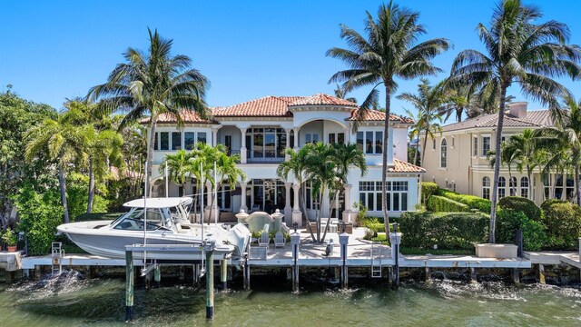 4216 Intracoastal Dr, Highland Beach, FL 33487 - back of house with boat lift, a tiled roof, a water view, and stucco siding