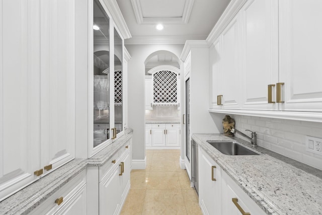 4216 Intracoastal Dr, Highland Beach, FL 33487 - kitchen featuring a sink, white cabinets, backsplash, light stone counters, and crown molding