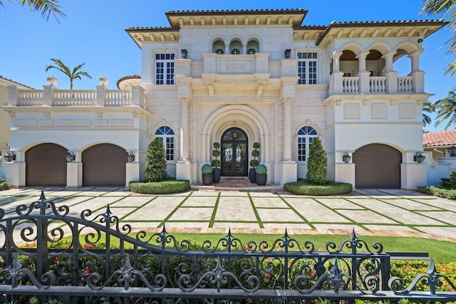 4216 Intracoastal Dr, Highland Beach, FL 33487 - mediterranean / spanish-style home with a balcony, an attached garage, concrete driveway, french doors, and a fenced front yard