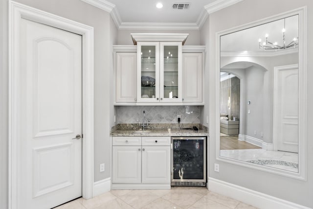 4216 Intracoastal Dr, Highland Beach, FL 33487 - indoor wet bar with beverage cooler, arched walkways, ornamental molding, backsplash, and baseboards