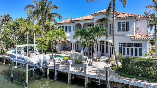 4216 Intracoastal Dr, Highland Beach, FL 33487 - rear view of property with a tiled roof, a balcony, stucco siding, and boat lift