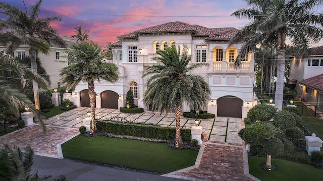 4216 Intracoastal Dr, Highland Beach, FL 33487 - mediterranean / spanish-style home featuring a balcony, driveway, a garage, stucco siding, and a tiled roof
