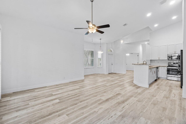 unfurnished living room featuring visible vents, high vaulted ceiling, a ceiling fan, and light wood finished floors