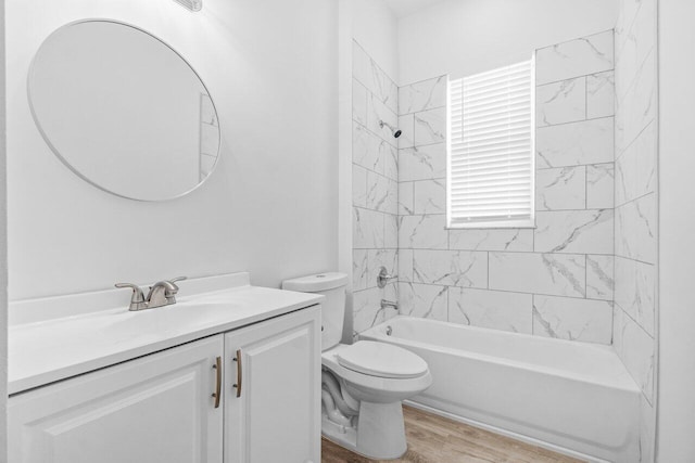 bathroom featuring vanity, toilet, wood finished floors, and shower / washtub combination