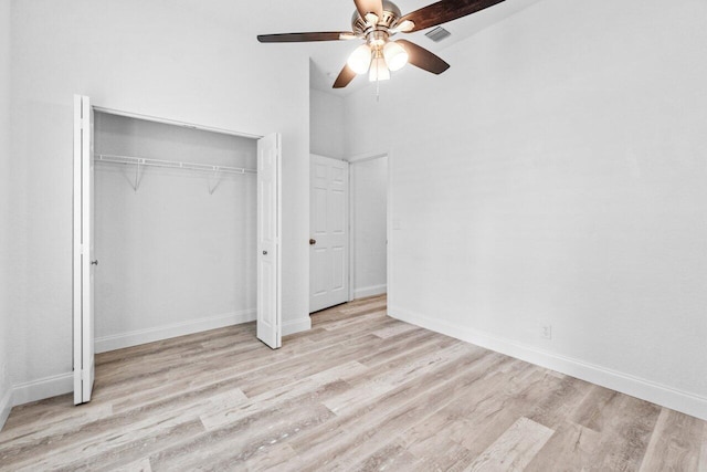 unfurnished bedroom featuring a closet, visible vents, baseboards, and wood finished floors