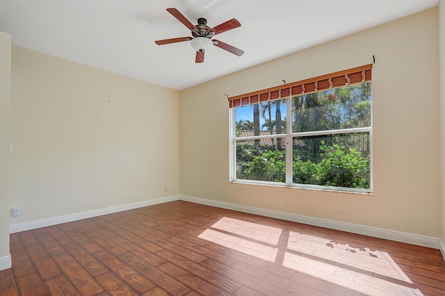 spare room with a ceiling fan, baseboards, and wood-type flooring