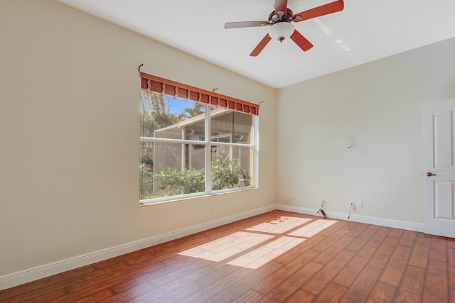 empty room with ceiling fan, baseboards, and wood finished floors