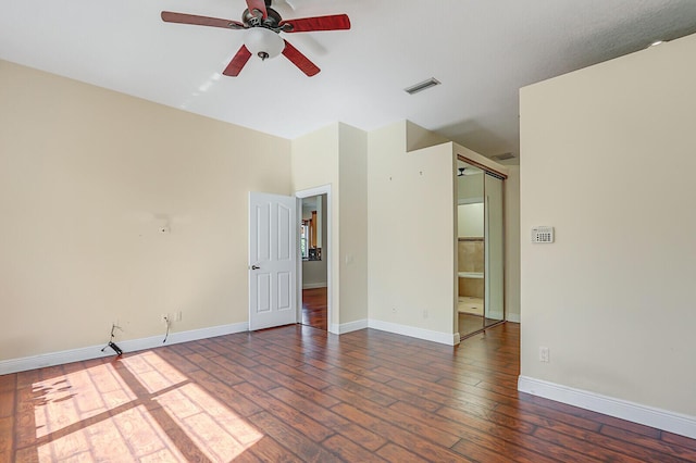 spare room with hardwood / wood-style floors, visible vents, a ceiling fan, and baseboards