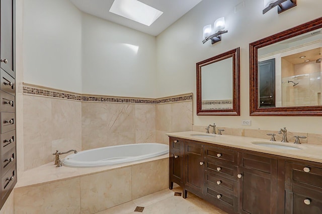 bathroom featuring double vanity, a skylight, a garden tub, and a sink