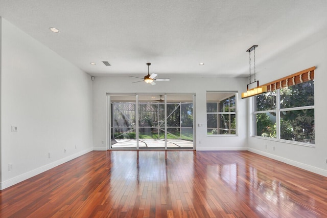 spare room with baseboards, a textured ceiling, a ceiling fan, and hardwood / wood-style flooring