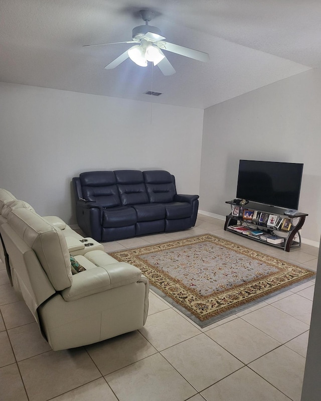 tiled living room with baseboards, visible vents, and ceiling fan