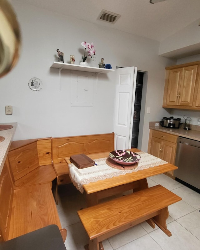 kitchen with visible vents, light brown cabinets, light countertops, light tile patterned floors, and stainless steel dishwasher