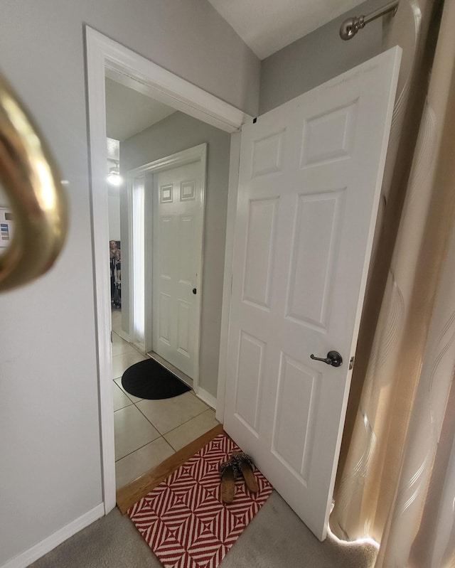 foyer featuring light tile patterned floors and baseboards