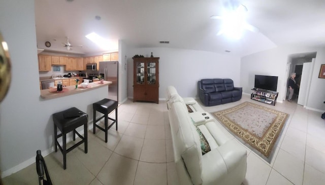 living area with light tile patterned flooring, visible vents, baseboards, and ceiling fan