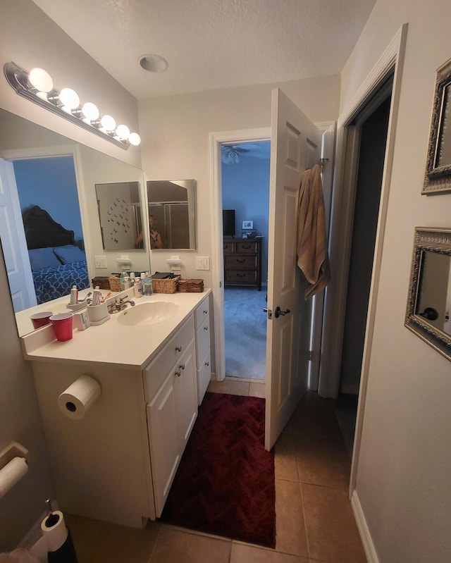 ensuite bathroom with tile patterned floors, a textured ceiling, ensuite bath, and vanity