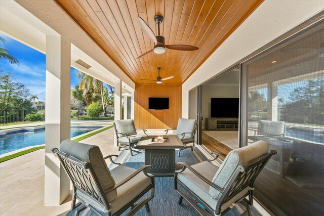 view of patio featuring a fenced in pool, fence, a ceiling fan, and an outdoor fire pit