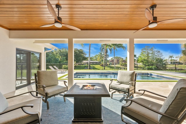 view of patio with an outdoor fire pit, a lanai, fence, a fenced in pool, and ceiling fan