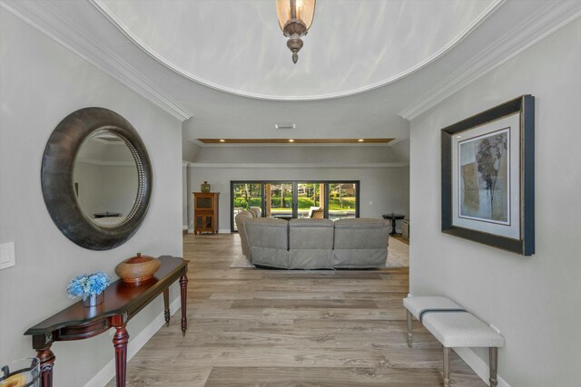 corridor featuring visible vents, crown molding, baseboards, and wood finished floors