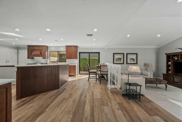 kitchen featuring visible vents, light wood-type flooring, light countertops, and ornamental molding