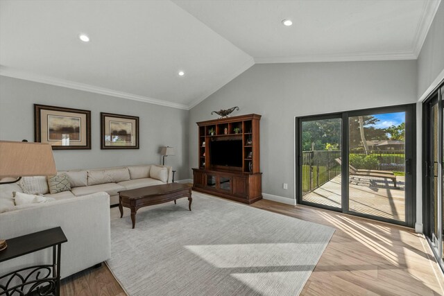 living room with baseboards, lofted ceiling, wood finished floors, and ornamental molding