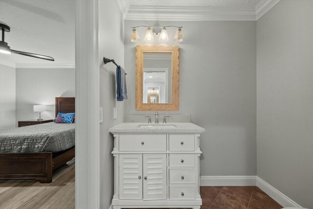 bathroom featuring baseboards, ornamental molding, ensuite bathroom, and tile patterned flooring