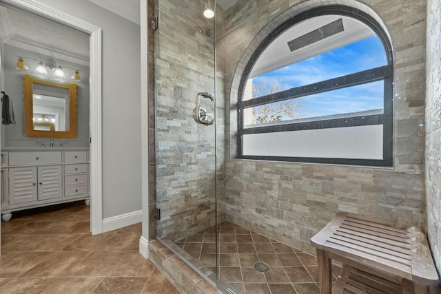 full bath with a shower stall, tile patterned flooring, crown molding, baseboards, and vanity