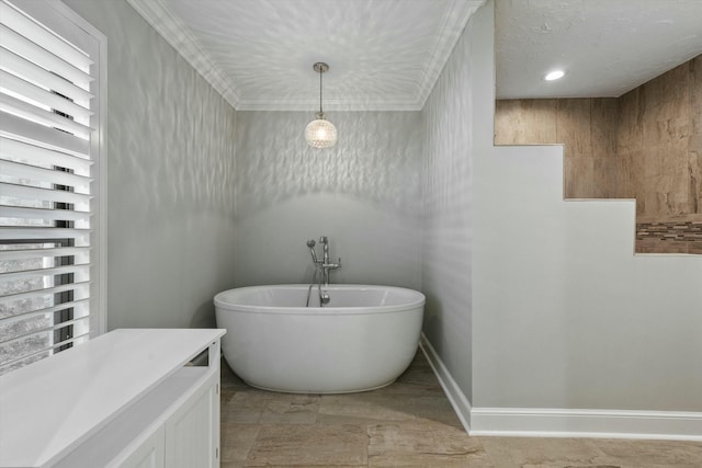 bathroom with baseboards, a freestanding bath, and ornamental molding