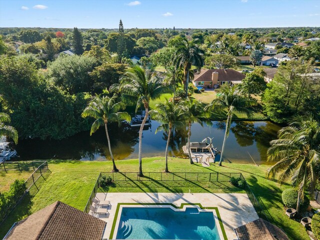 view of swimming pool featuring a lawn, a water view, a fenced in pool, and fence