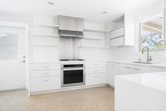 kitchen with stainless steel oven, modern cabinets, open shelves, and a sink