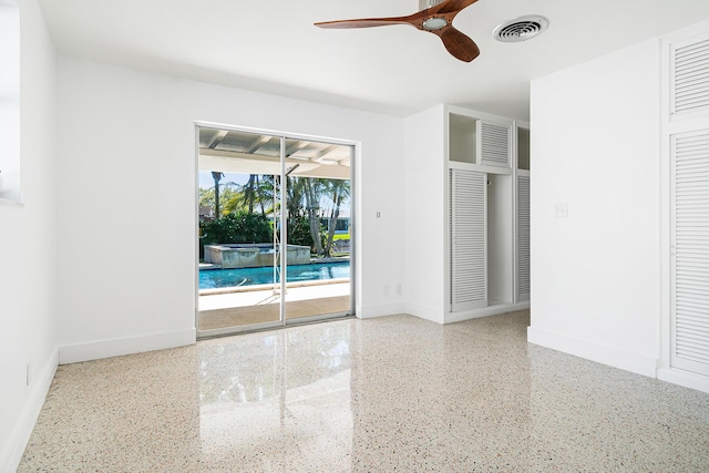 empty room featuring visible vents, baseboards, speckled floor, and ceiling fan