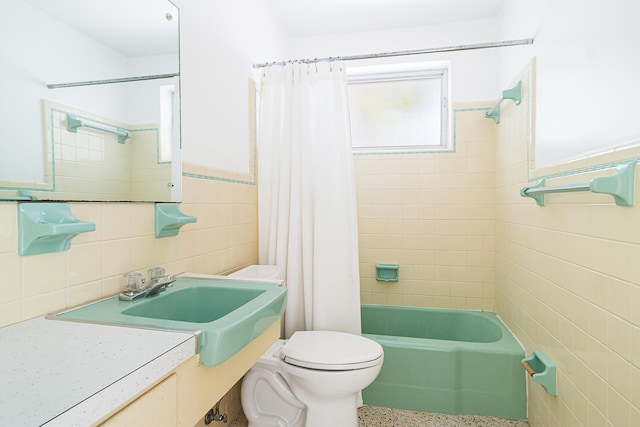 full bath featuring speckled floor, wainscoting, tile walls, toilet, and shower / tub combo with curtain