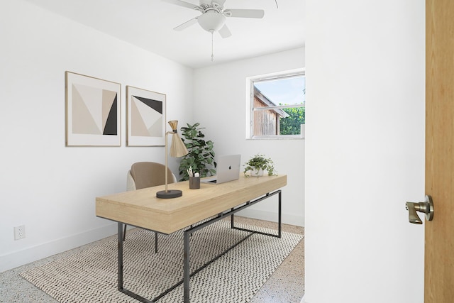 office area with a ceiling fan, baseboards, and speckled floor