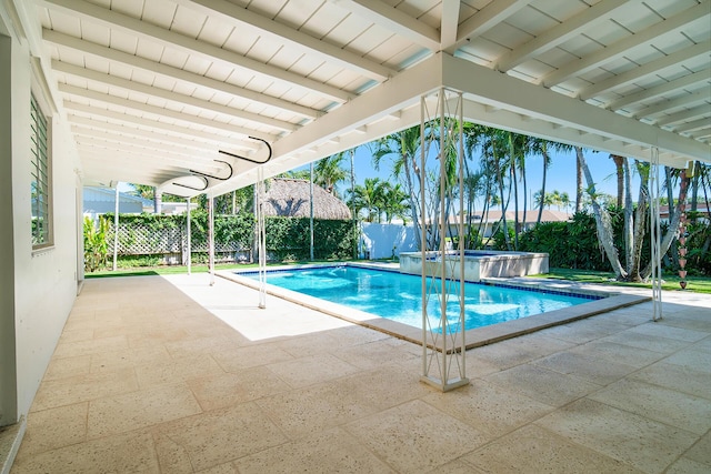 view of pool with a pool with connected hot tub, a patio area, and a fenced backyard